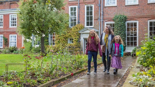 A family exploring the garden at the rear of Mompesson House in Wiltshire
